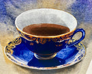 Decorative blue teacup with gold patterns on a matching saucer against a textured background