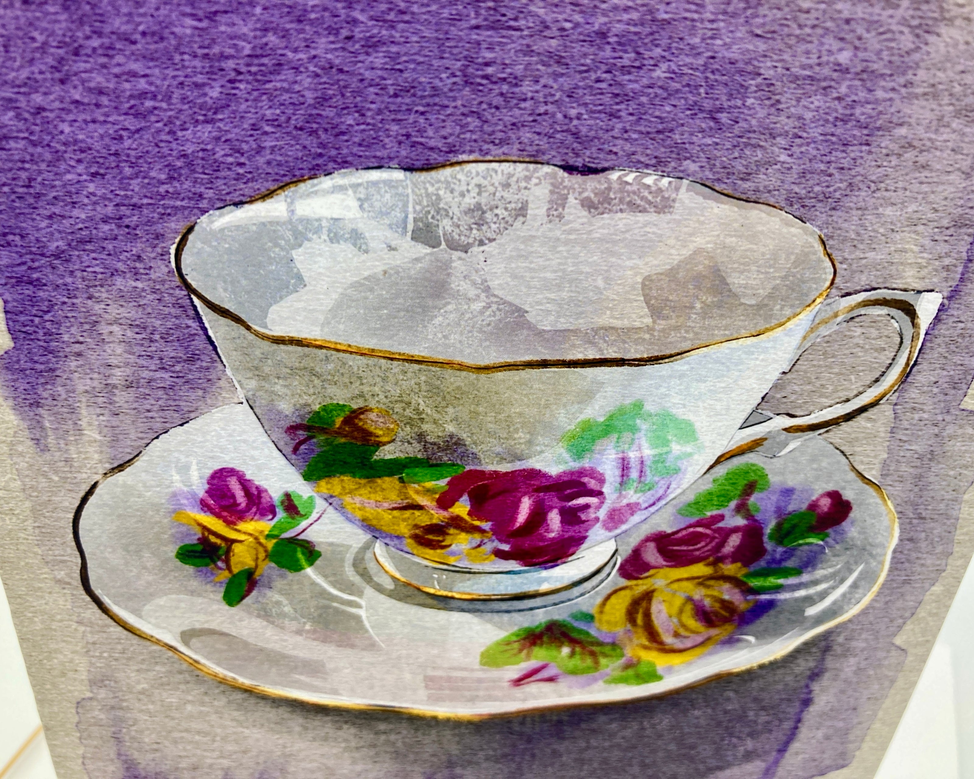 Teacup and saucer with floral design on a textured purple and gray background