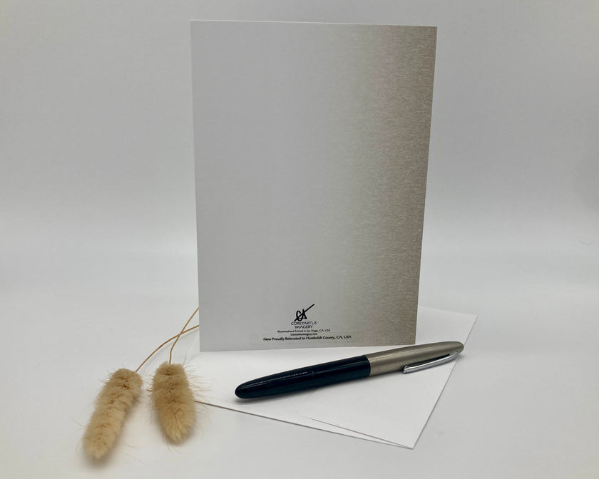 Back of a greeting card displayed with a pen, and decorative items on a white surface