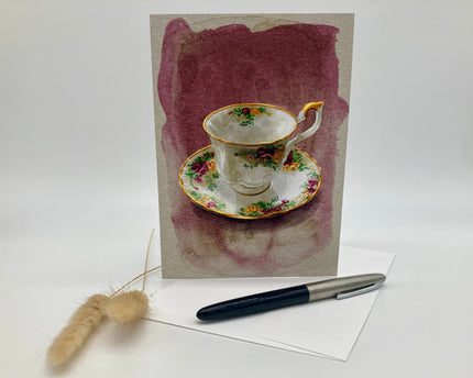 Decorative card with a teacup design, pen, and brush on a white background