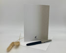 Back of a greeting card displayed with pen and decorative item on a white background