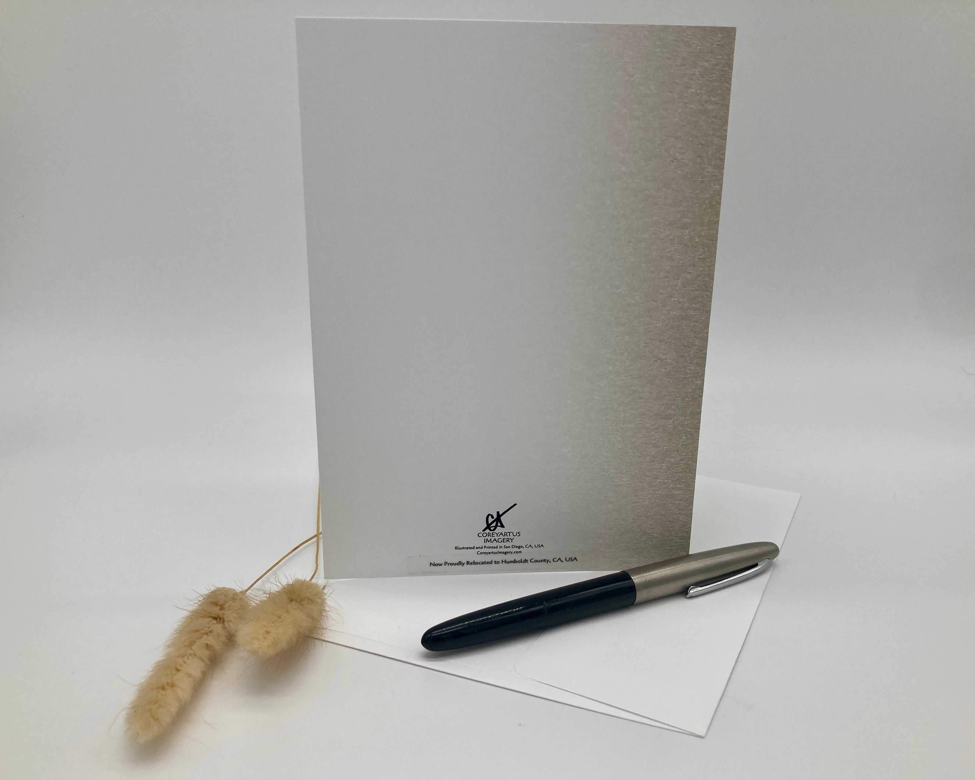 Notebook, pen, and decorative item on a white surface