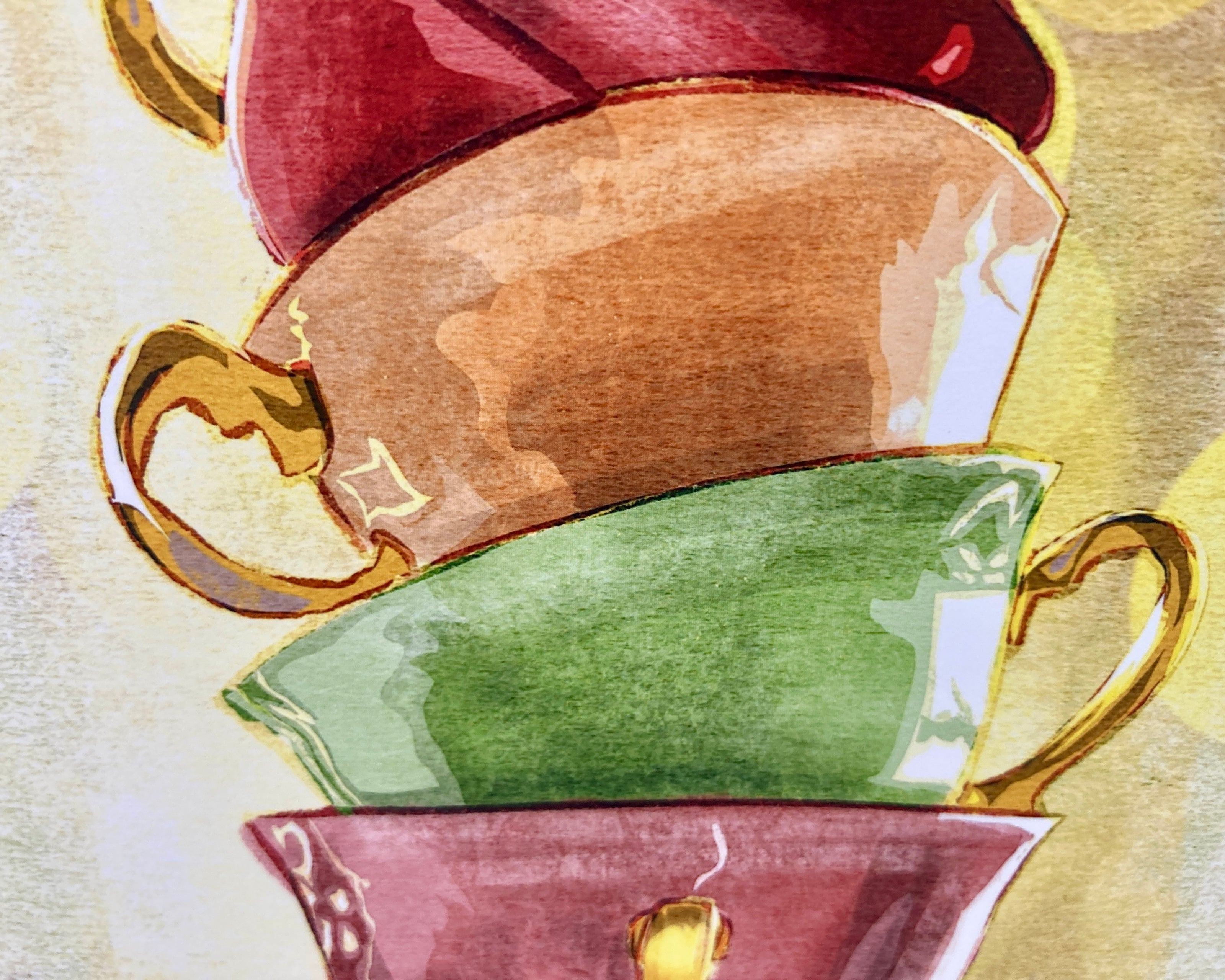 Three ceramic teacups in red, gold, and green on a textured beige background