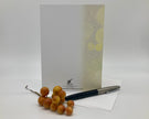 Back of greeting card displayed with a pen and grapes on a white background