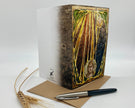 Decorative book with artistic cover design, pen, and paper on a white background