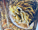 Close-up of a detailed carving of a lion's head on a textured surface.