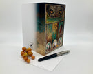 Decorative box with artistic design, pen, and grapes on a white background