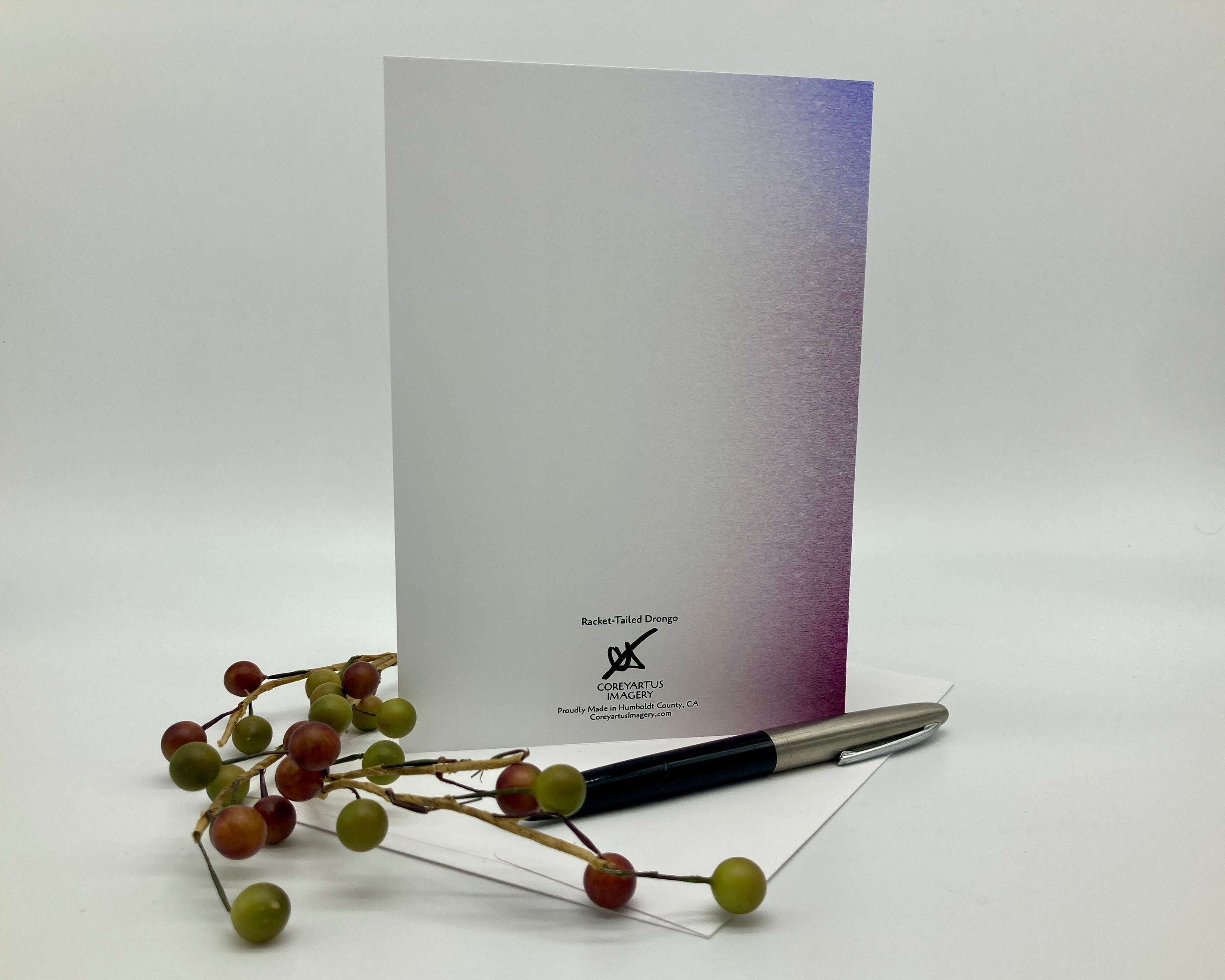 Note card with a pen and decorative branches on a white background