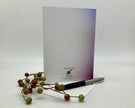Note card with a pen and decorative branches on a white background
