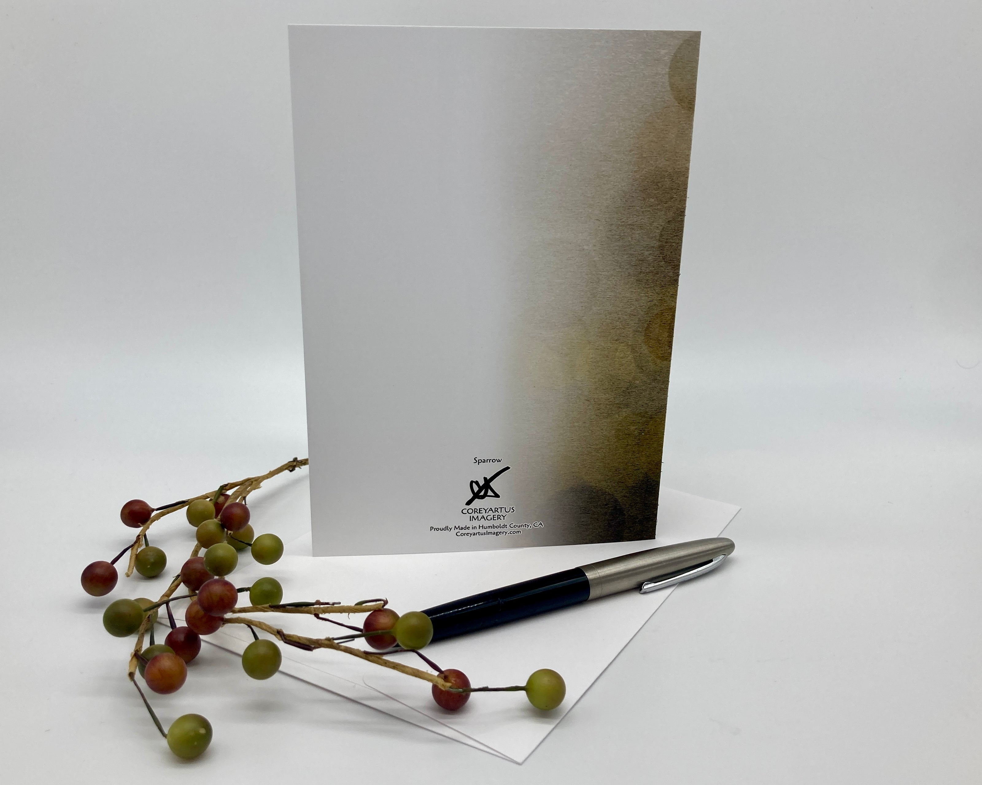 Greeting card with pen and decorative branches on a white background