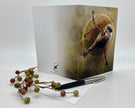 Greeting card with bird design on a white surface with berries and pen