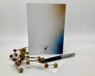 Greeting card with a pen and decorative branches on a white background