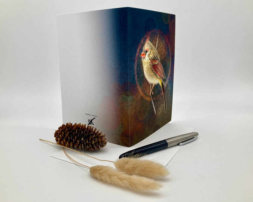 Open greeting card with bird illustration on cover, pen, and decorative elements on white background
