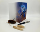 Greeting card with a blue bird design on a white background with decorative elements.