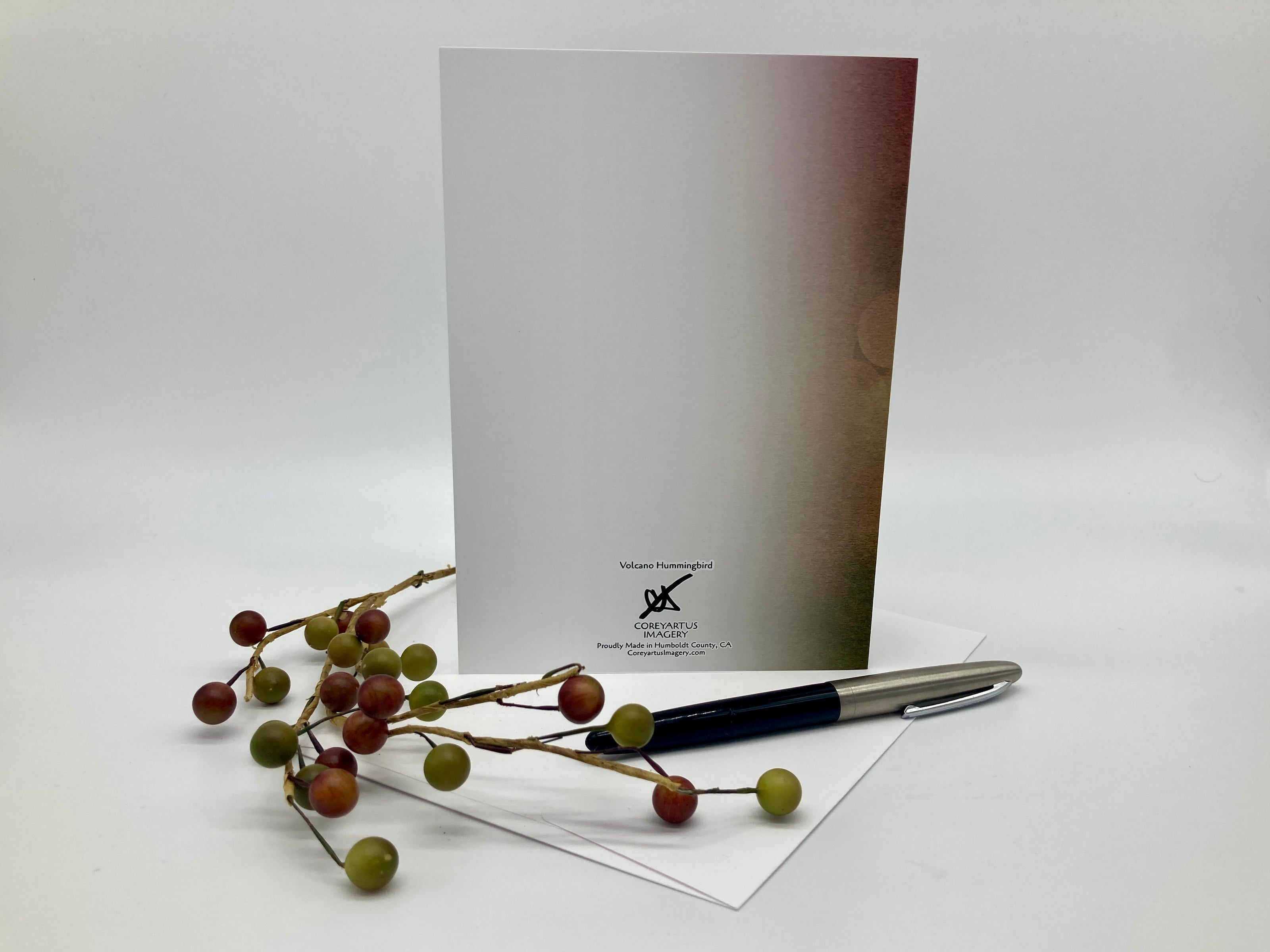 Greeting card with pen and decorative branches on a white background