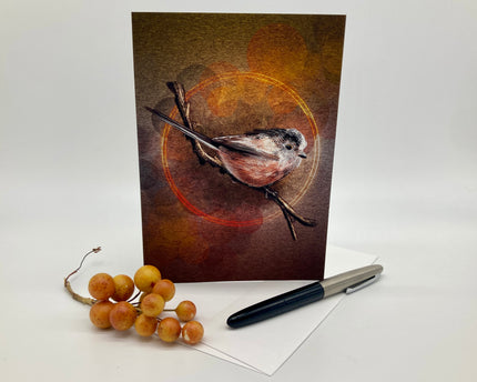 Card with a bird illustration on a brown background, next to berries and a pen.
