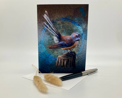 Greeting card with a bird illustration on a white surface with a pen and decorative items.