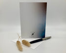 Greeting card with a pen and decorative items on a white background