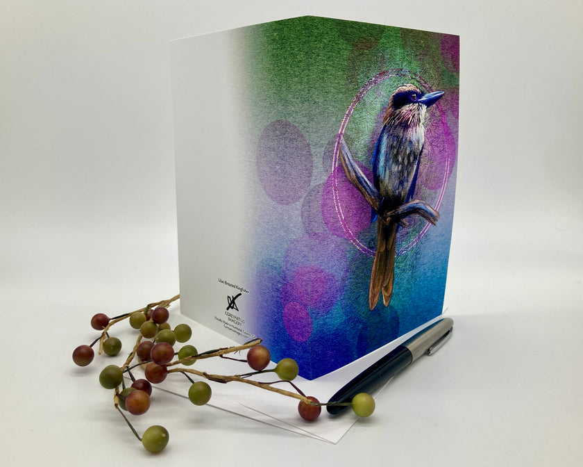 Splayed open greeting card displayed with a sprig of fake berries and a pen.