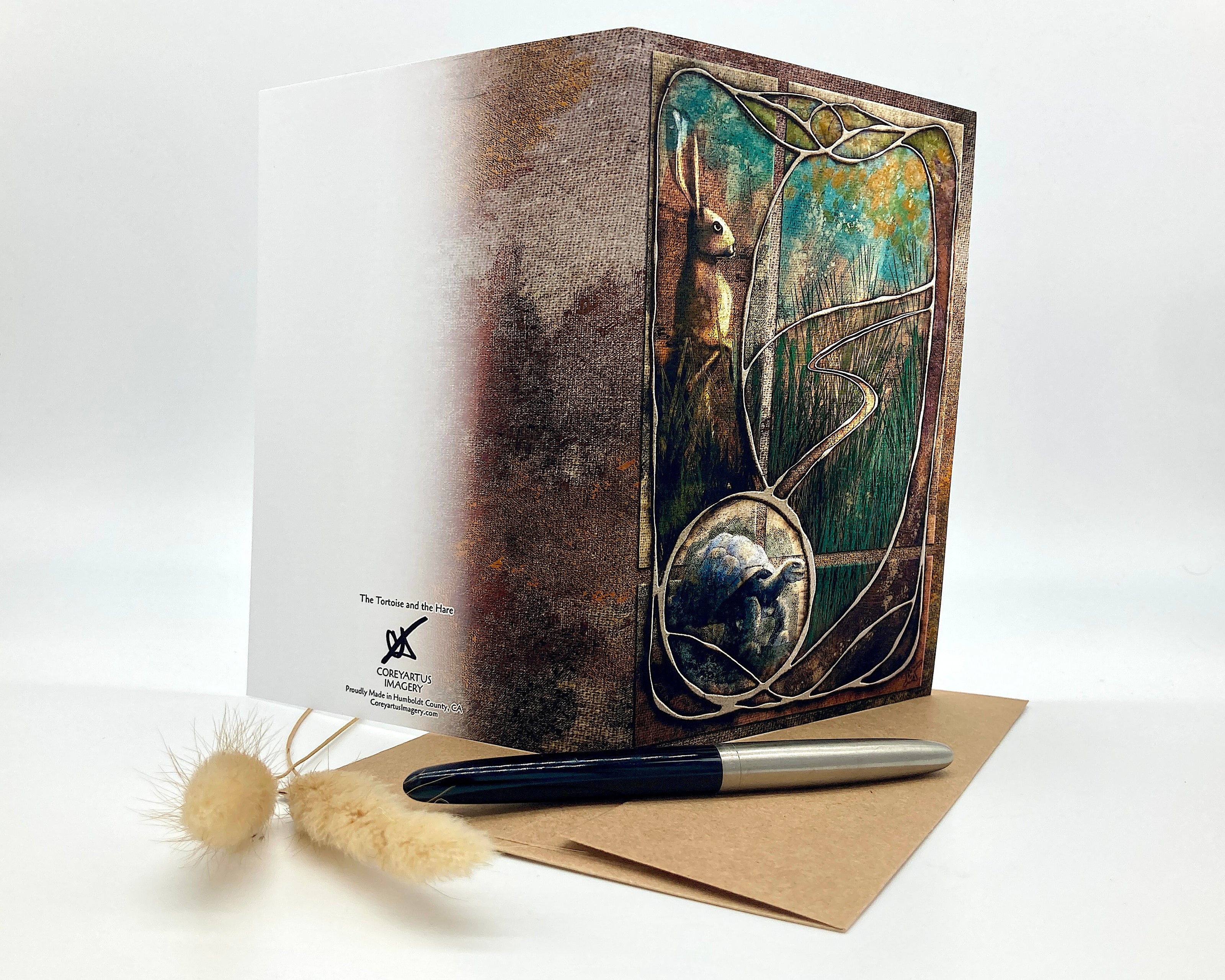 Decorative greeting card with artistic design, pen, and envelope on a white background