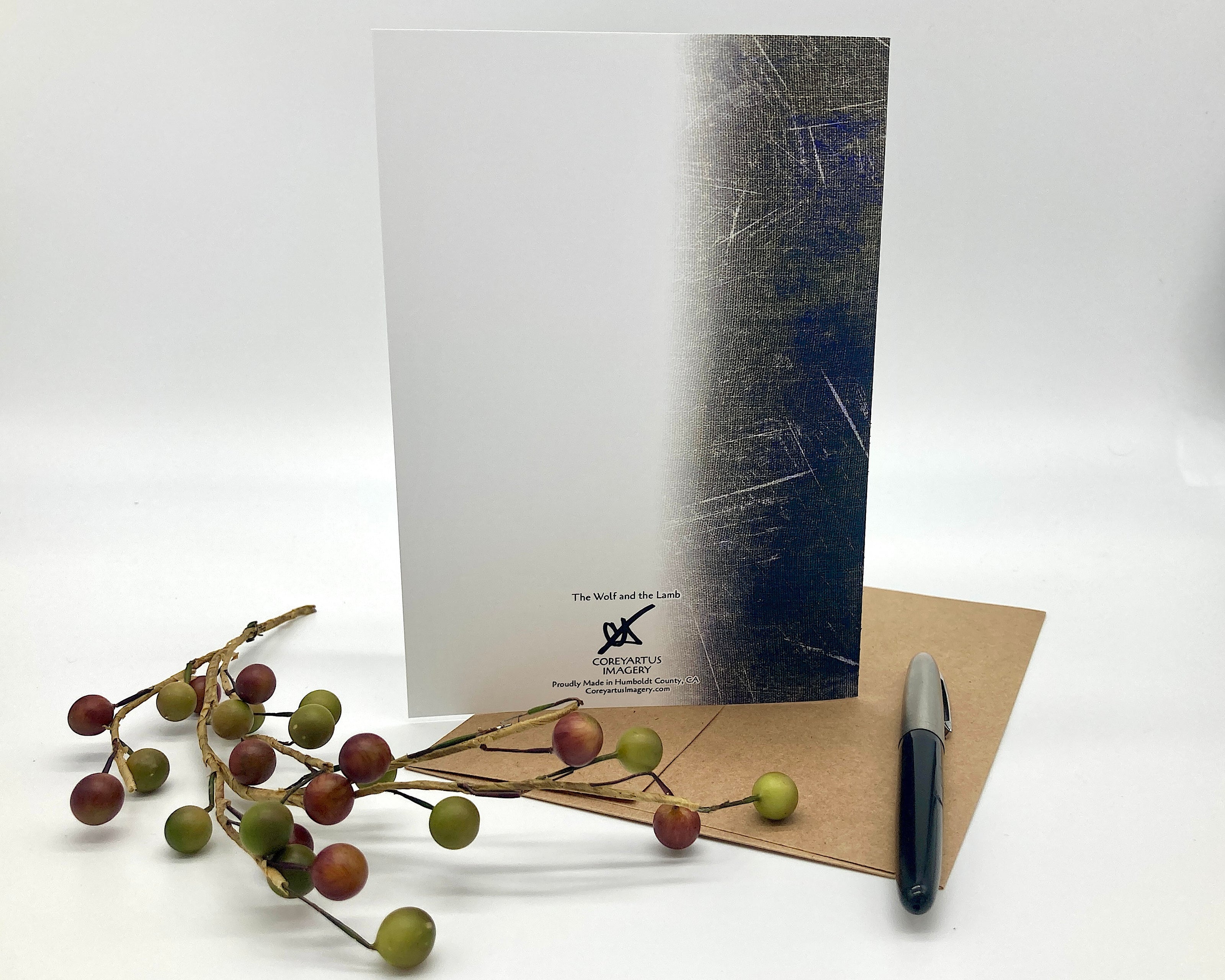 Greeting card, pen, and decorative branch on a white background