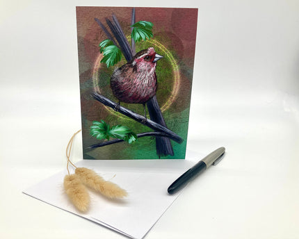 Greeting card with a bird design on a white surface with a pen and decorative item.