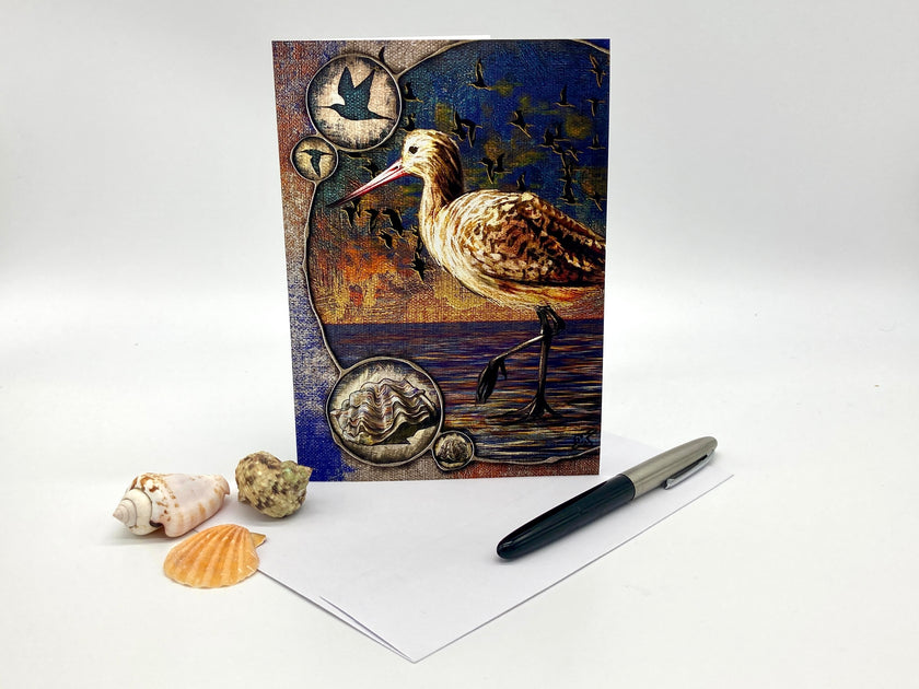Decorative greeting card with a bird design on a white surface with shells and a pen.