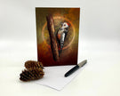 Greeting card with a woodpecker illustration on a branch, accompanied by a pen and pine cone on a white background.