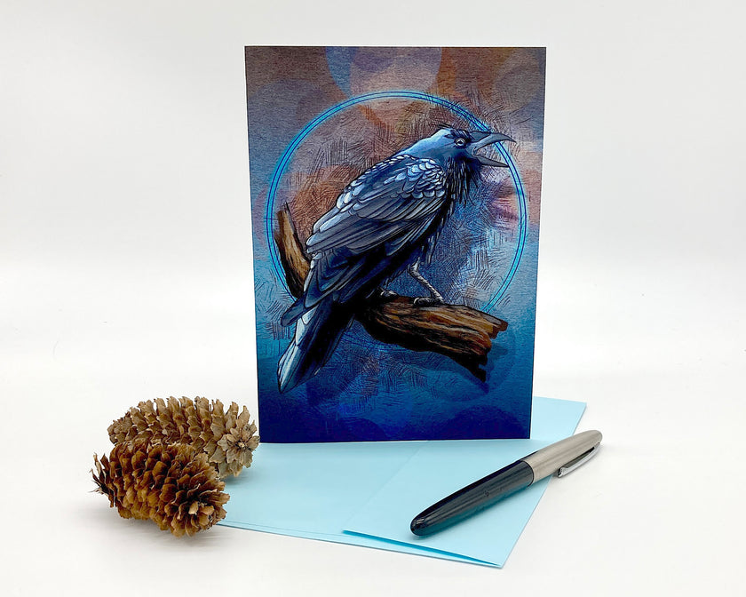 Greeting card with a blue bird design, pen, and pine cone on a white background