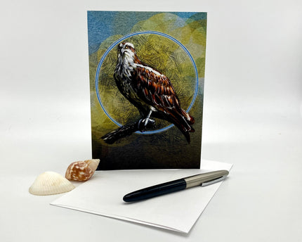 Greeting card with a bird design on a white surface with a pen and shell.