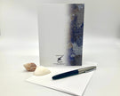 Notebook with a pen and shell on a white background