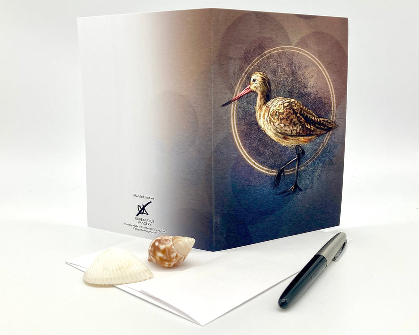 Greeting card with a bird design on a white surface with a pen and shell.