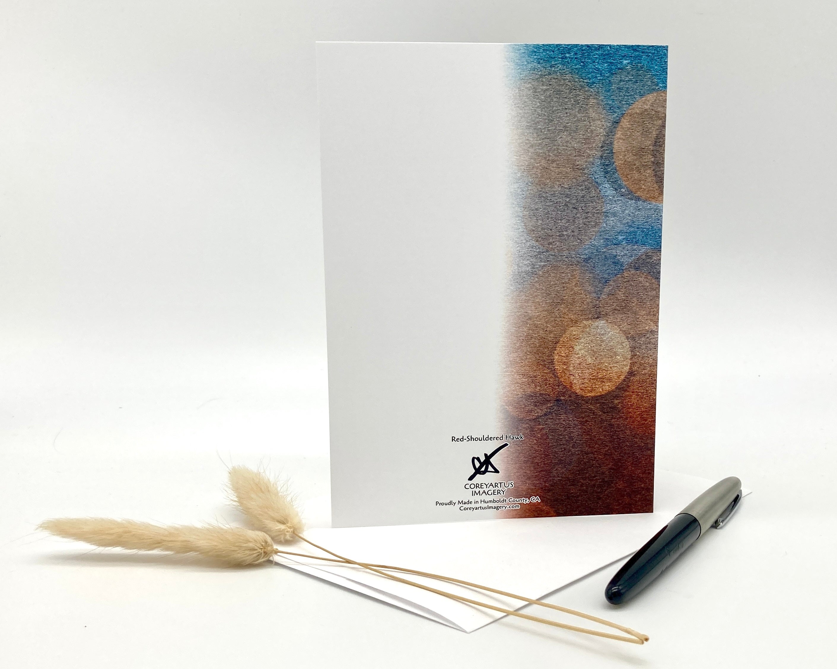 Notebook with a pen and dried plants on a white background