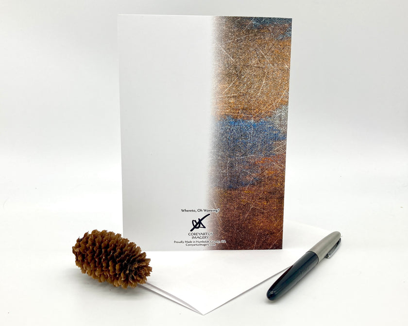 Greeting card with textured cover, pen, and pine cone on a white background