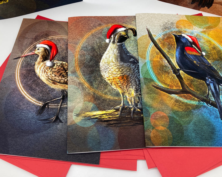 Three Christmas-themed greeting cards with birds wearing Santa hats on a white surface.