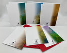Backside of six greeting cards with artistic designs on a gray background