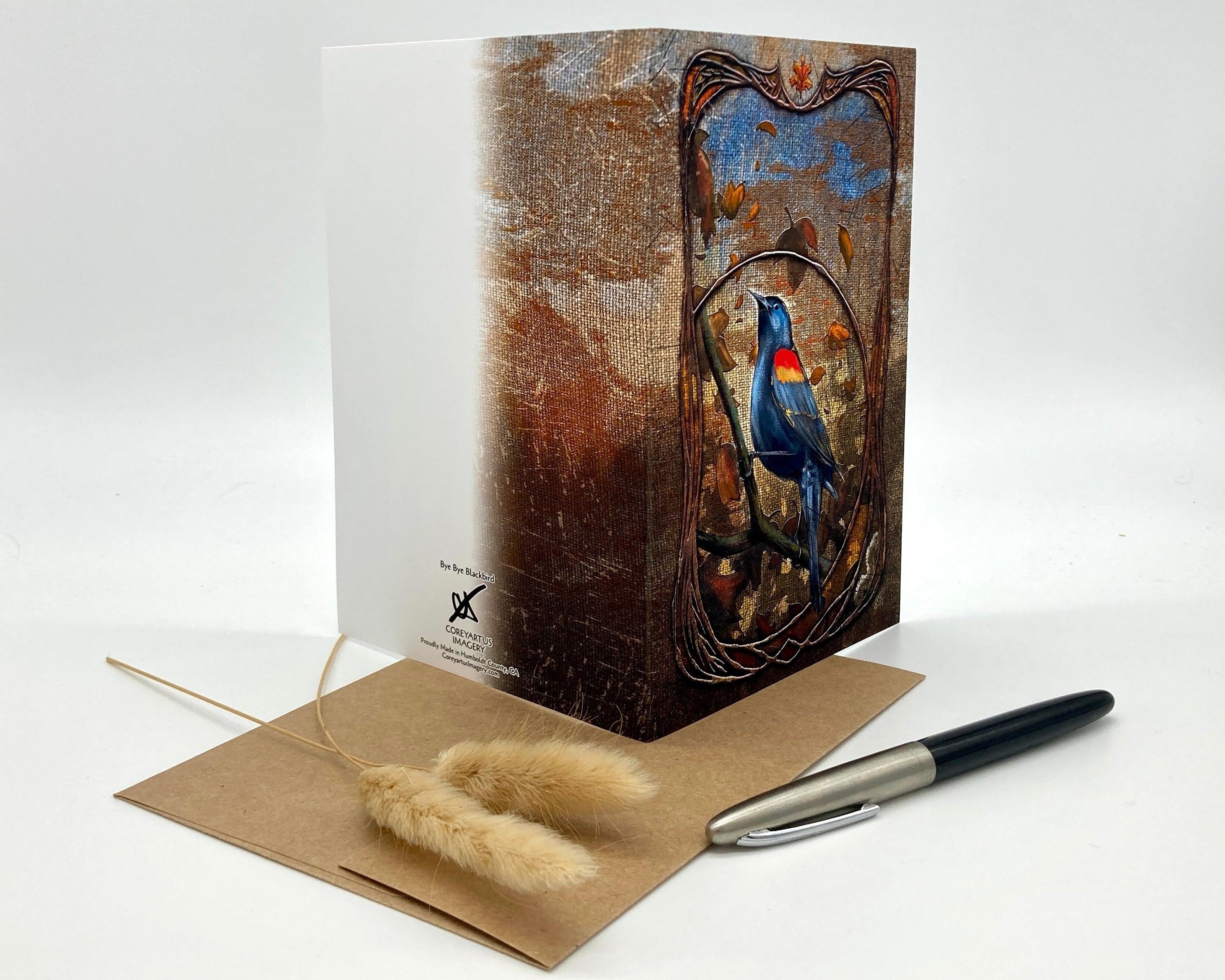 Greeting card with bird design, envelope, and pen on a white background