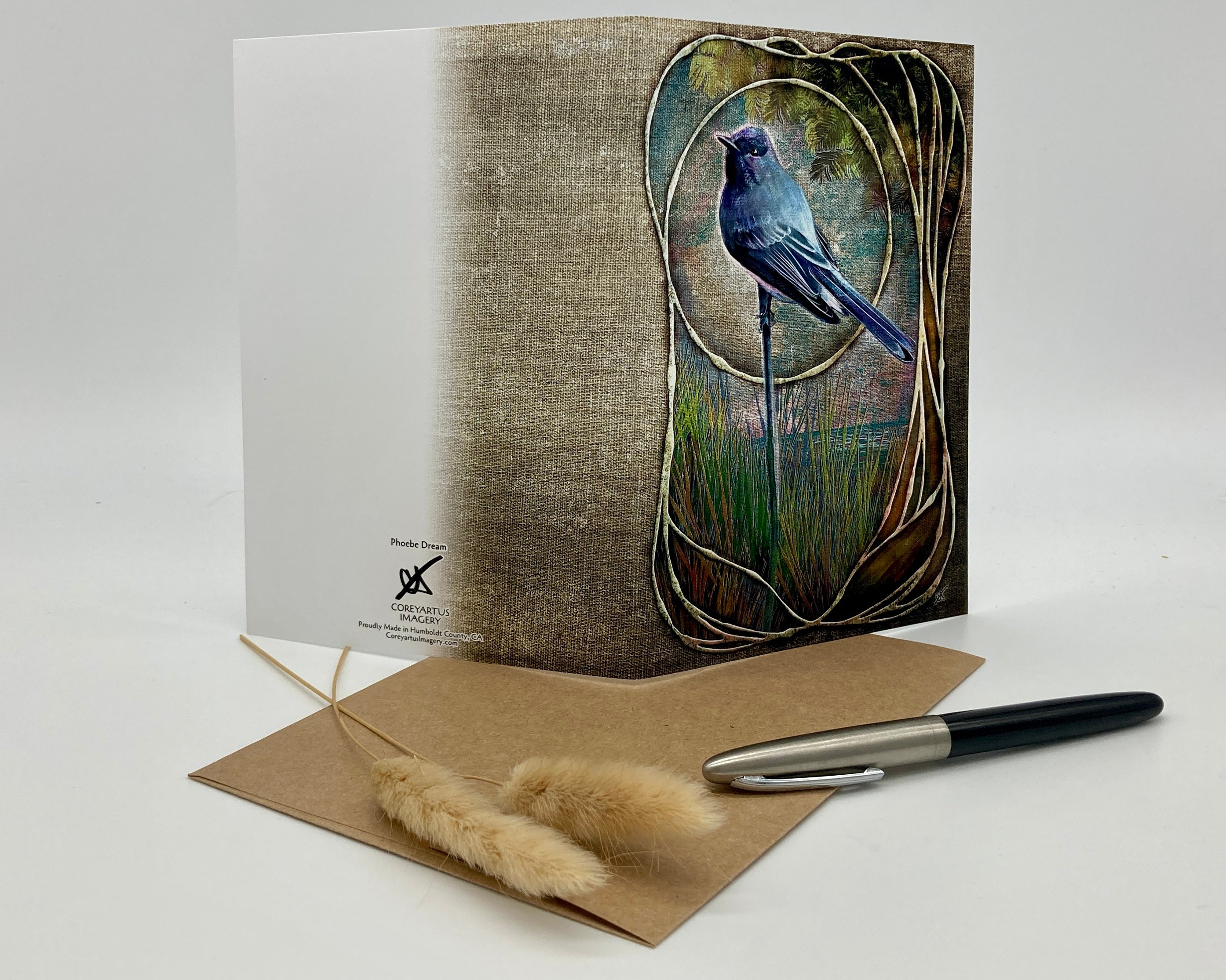 Greeting card with a bird design on a textured background, accompanied by an envelope and pen.