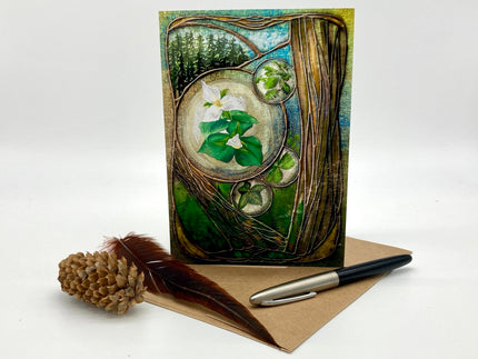 Greeting card with nature-themed design, pen, and pine cone on a white background