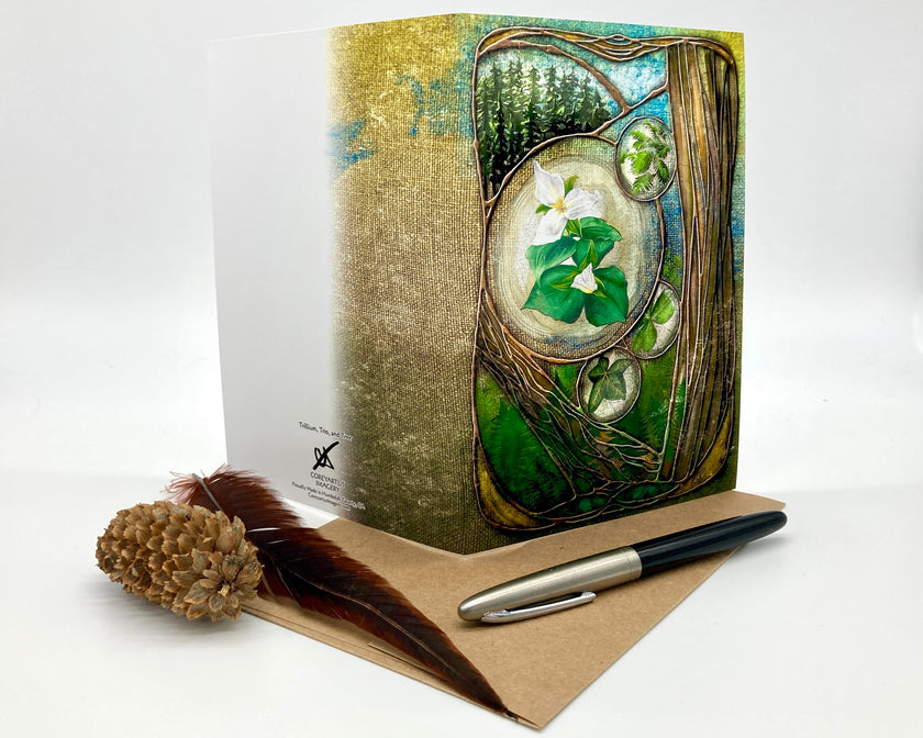 Decorative notebook with nature-themed cover, pen, and feather on a white background