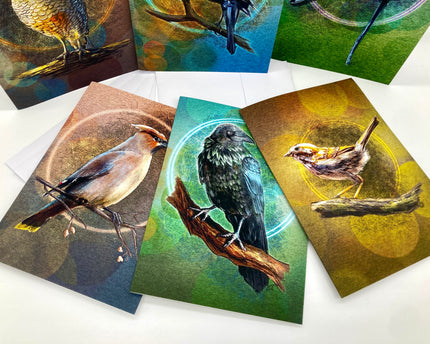 Set of greeting cards with bird illustrations on a white surface