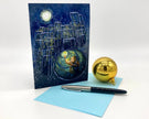 Greeting card with artistic design of a cityscape at night, pen, and gold ornament on a white background
