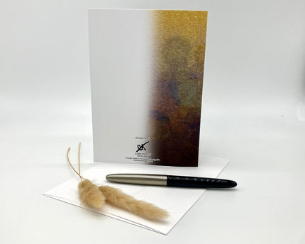 Pen, feather, and card on a white background
