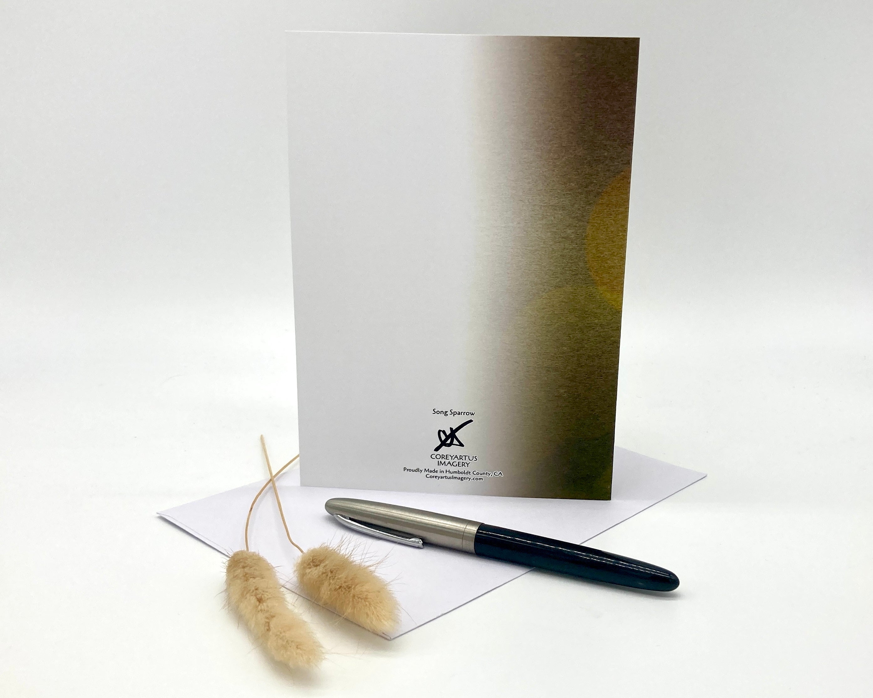 Pen and card on a white surface with a brand logo.
