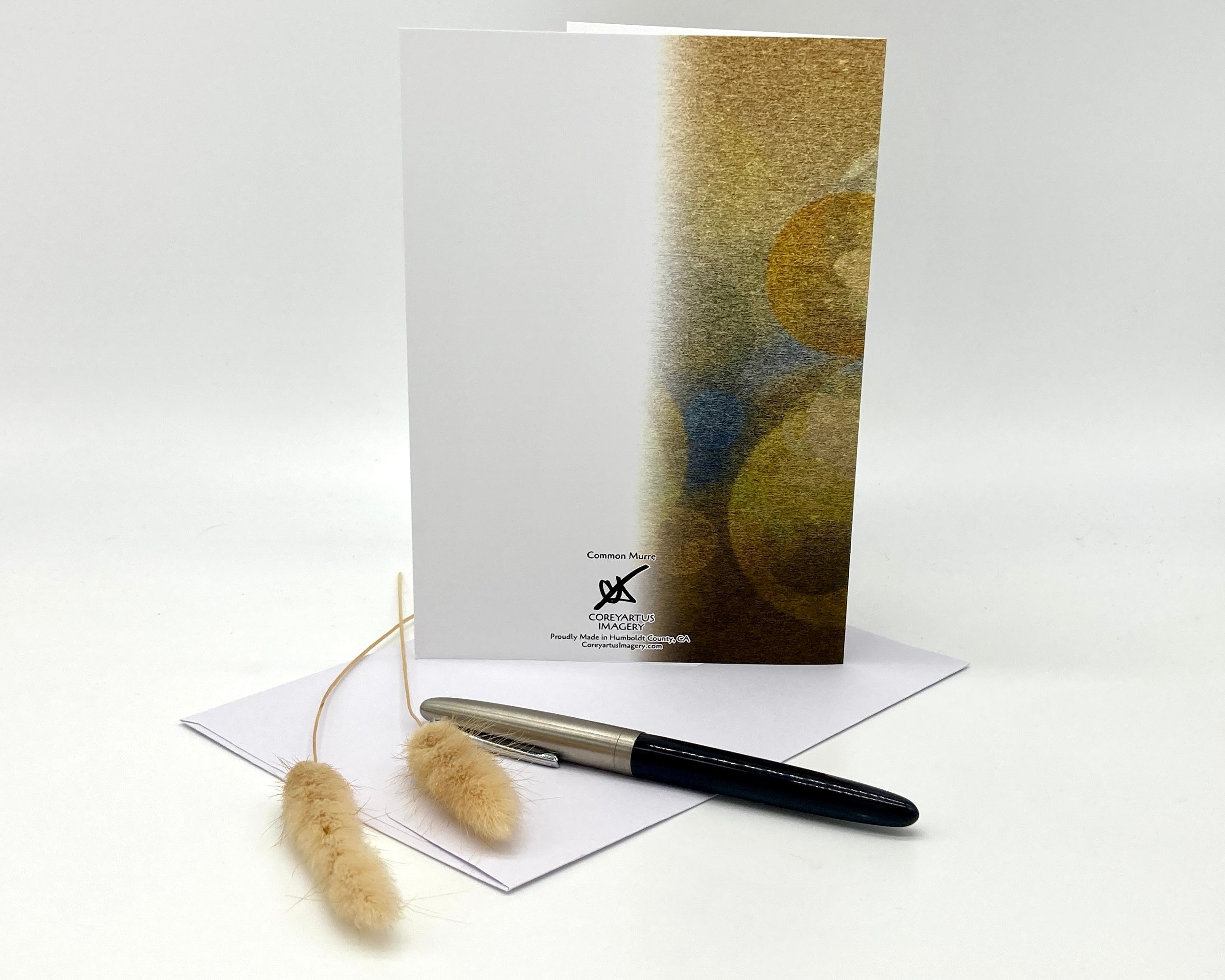Greeting card with abstract design, pen, and decorative elements on a white background