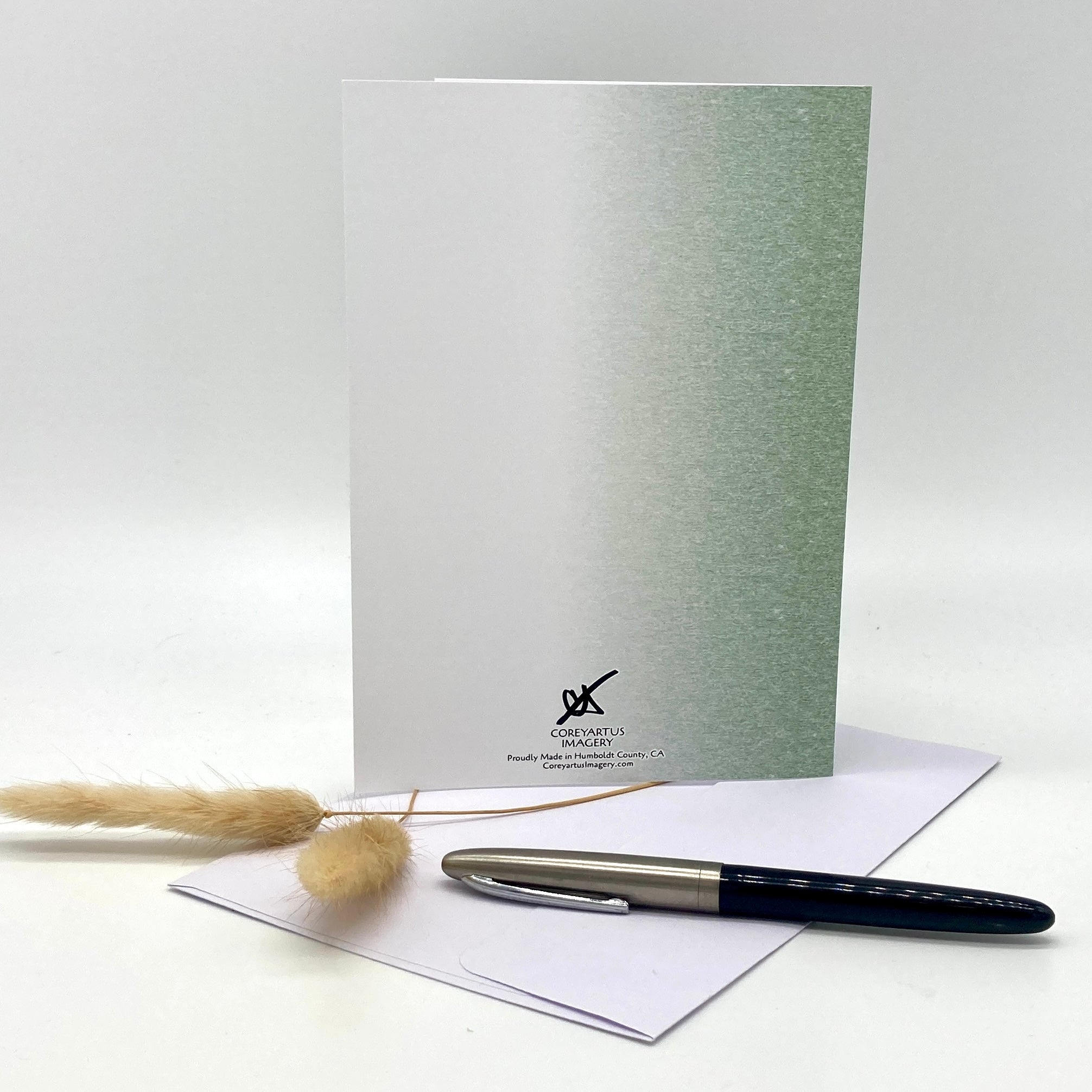 Greeting card with pen and envelope on a white background