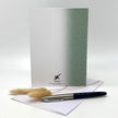 Greeting card with pen and dried plants on a white background