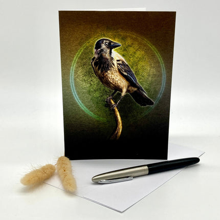 Greeting card with a bird design on a white surface with a pen and decorative item.