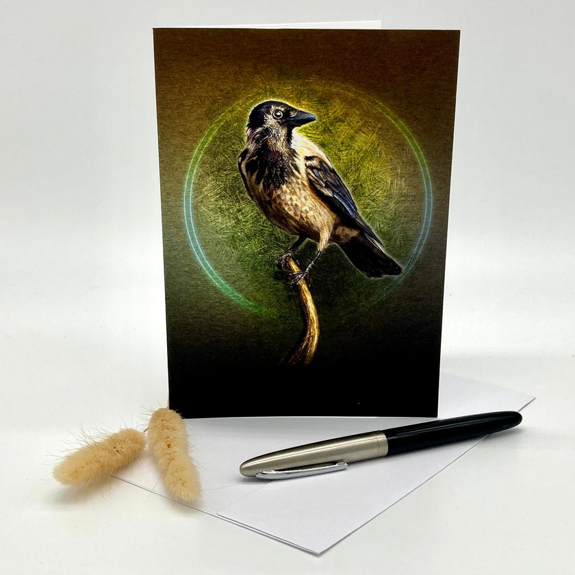 Greeting card with a bird design on a white surface with a pen and decorative item.