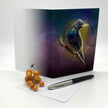 Greeting card with a bird design on a white surface with a pen and berries.
